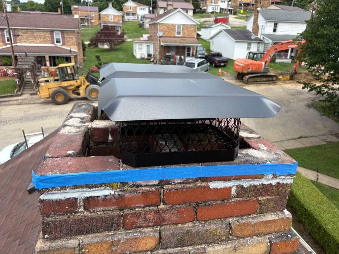 Finished chimney with a new grey cap over a repaired crown