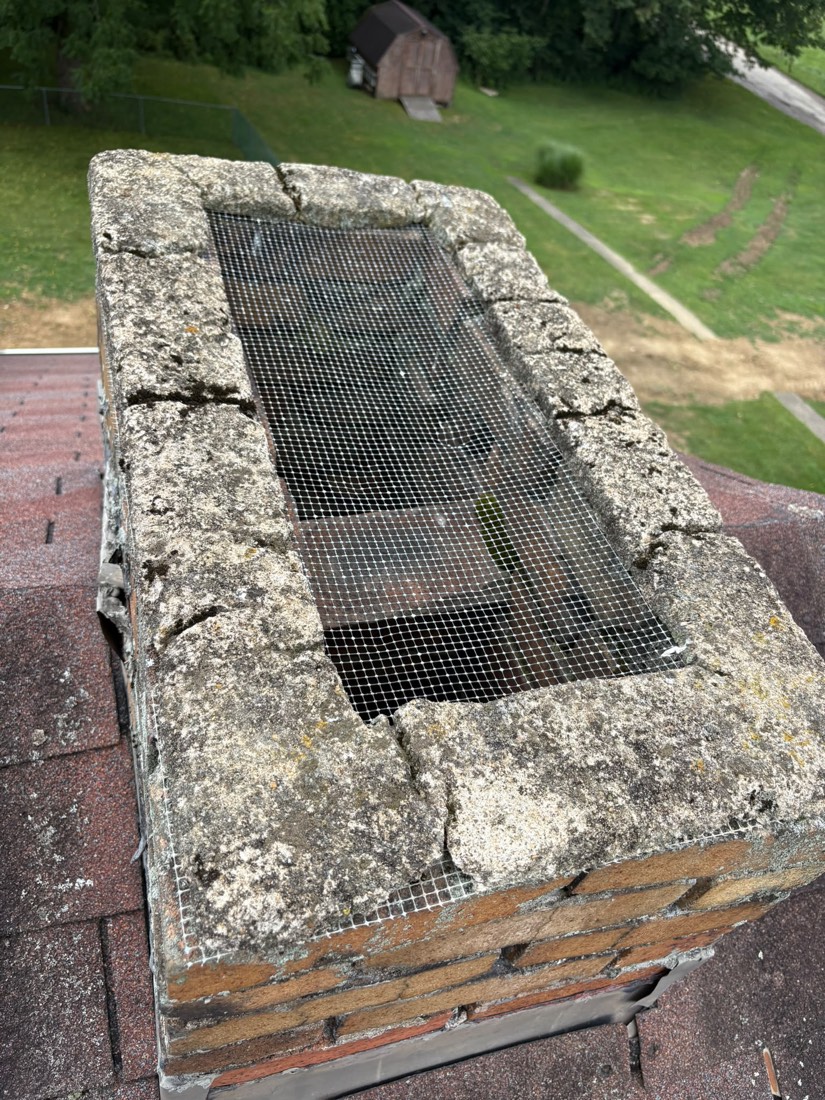Chimney crown cracked apart with an old rusted screen on top